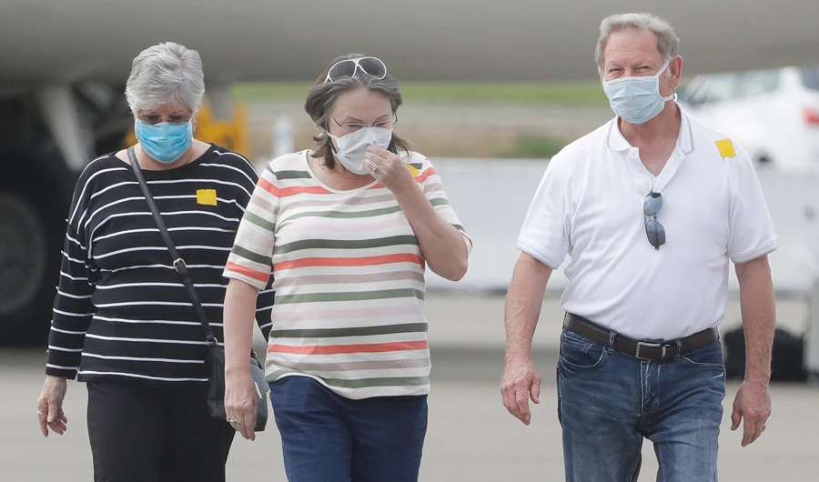 Passengers from the Grand Princess, a cruise ship carrying multiple people who have tested positive for COVID-19, walk on a tarmac before boarding a chartered plane in Oakland, Calif., Tuesday, March 10, 2020. (AP)