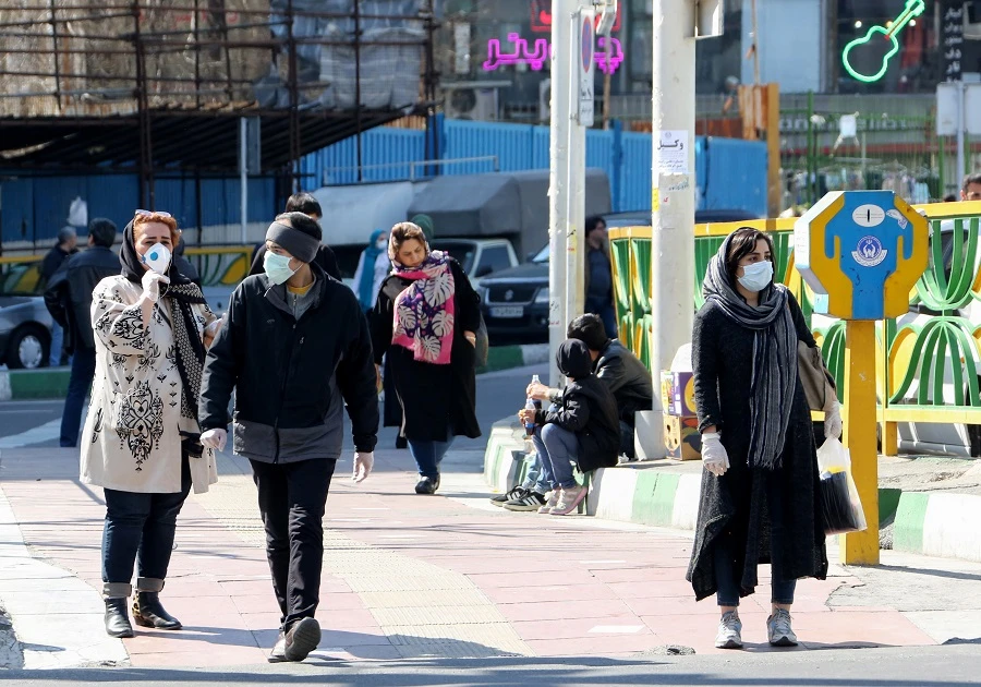 Iranian pedestrians walk while wearing protective masks in Tehran on March 10, 2020 amid the spread of coronavirus in the country. (File/AFP)