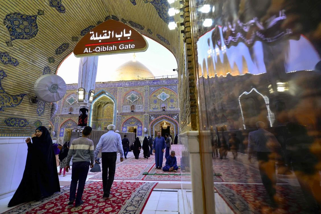 Visitors walk in an archway of the Imam Ali shrine, in the holy Iraqi central city of Najaf where the first case of novel coronavirus infection in the country was confirmed, on March 10, 2020. (AFP)
