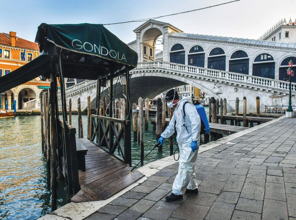 A worker sprays disinfectant at the Rialto Bridge in Venice, after Italy imposed unprecedented restrictions on its 60 million people to stop the coronavirus. (AFP)