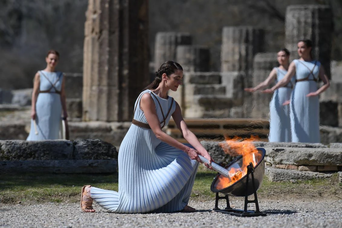 A woman dressed as a priestess lights the Olympic flame during a ceremony in ancient Olympia, ahead of Tokyo 2020 Games on March 12, 2020. (AFP)