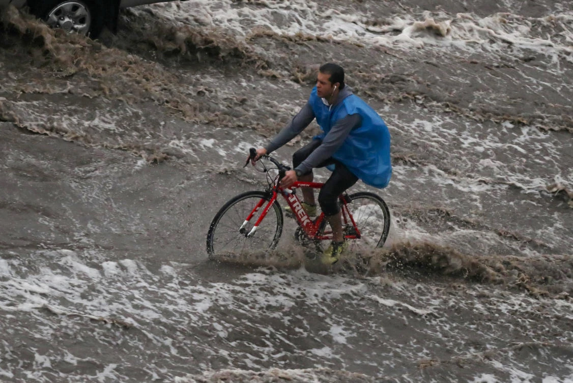 A man rides a bicycle during a thunderstorm and heavy rains in Cairo, as the government announced a day off while the rain exceeds the infrastructure's capacity in most cities, Egypt March 12, 2020. (Reuters)