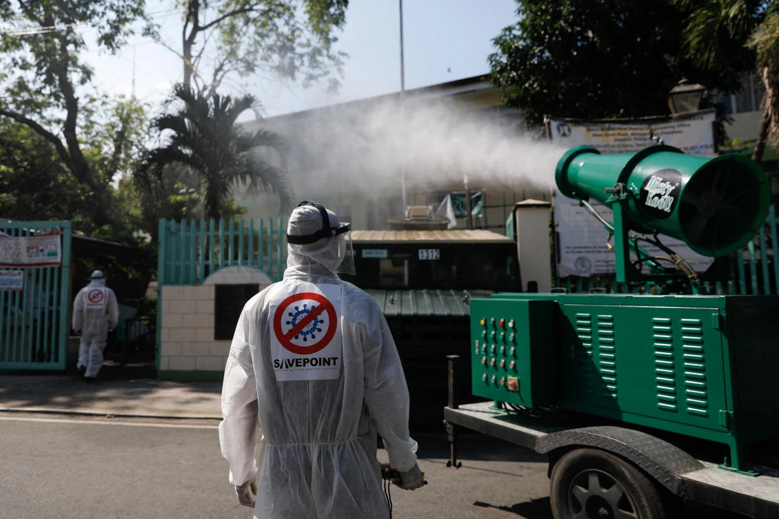 Workers disinfect a school following new cases of coronavirus in the city, in San Juan, Metro Manila, Philippines, Mar. 9, 2020. (Reuters)