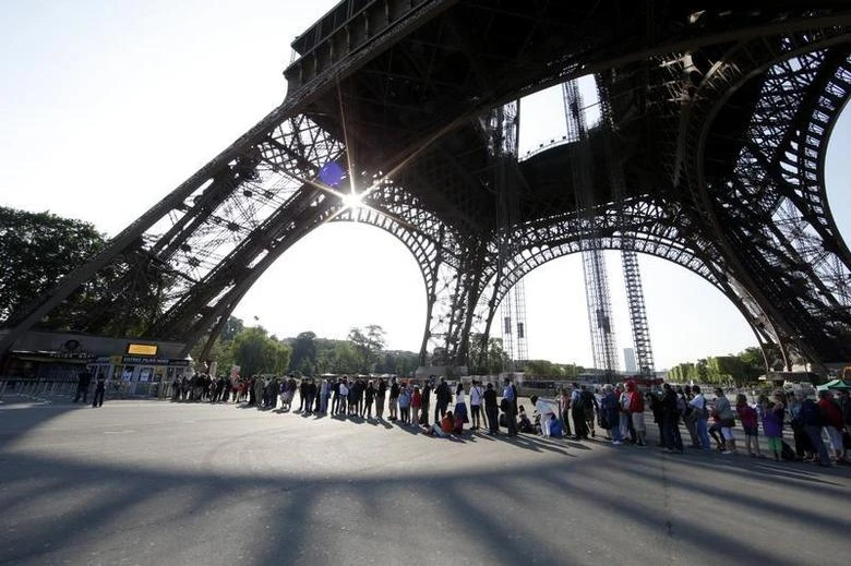 Tourists wait in line at the bottom of the Eiffel tower in Paris. (Reuters)