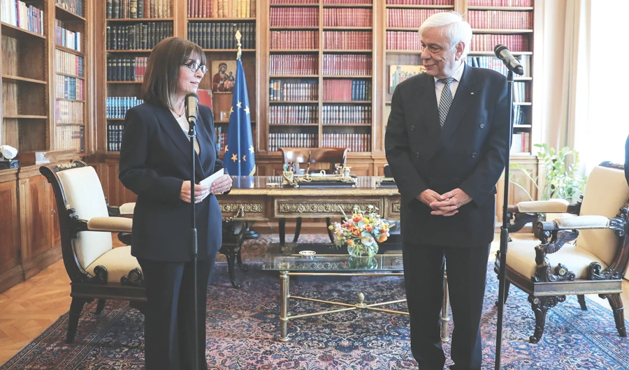 Newly sworn-in President Katerina Sakellaropoulou, left, and outgoing Greek President Prokopis Pavlopoulos during the handover ceremony at the presidential palace in Athens on Friday. (AFP)