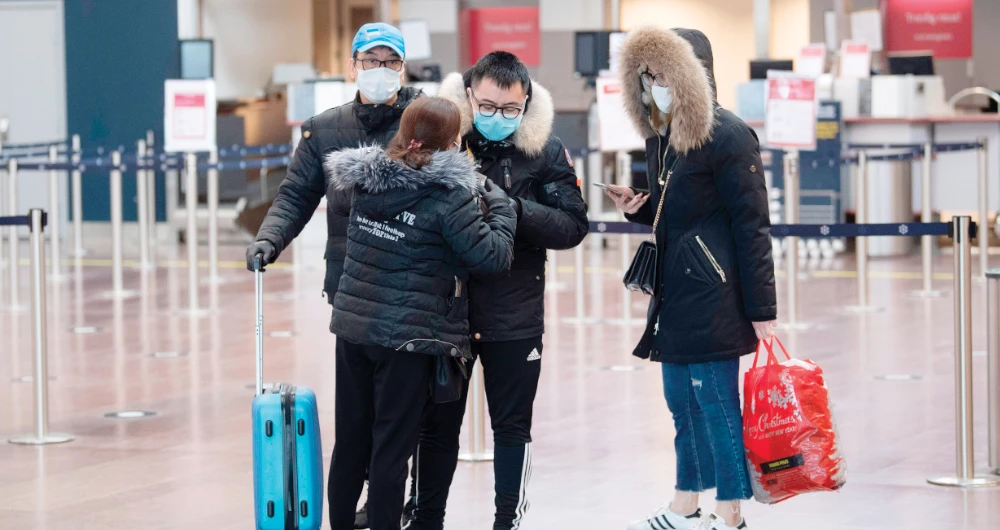 Travelers stand at Arlanda international airport outside Stockholm, where flights have been canceled due to concerns over the novel coronavirus. (AFP)