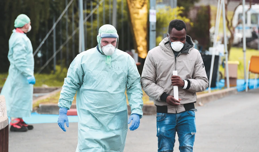 A hospital worker escorts a patient at a temporary emergency structure set up at the Brescia hospital in Lombardy, Italy, on Friday. (AFP)