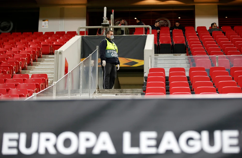 A staff member wearing a mask inside the empty stadium prior to a football match at the Karaiskakis Stadium in Piraeus, Greece, on Thursday. (AFP)