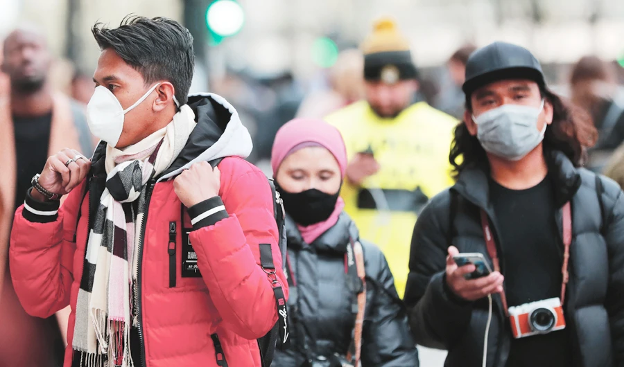 People wearing face masks walk along Oxford Street in London on Saturday. The steps being implemented globally increasingly mirror those taken by China. (AP)