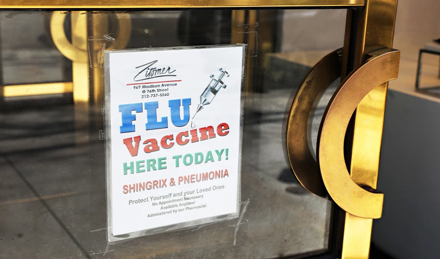 A flu vaccine sign is seen in the window of Zitomer on Madison Avenue on March 13, 2020 in New York City. (AFP)