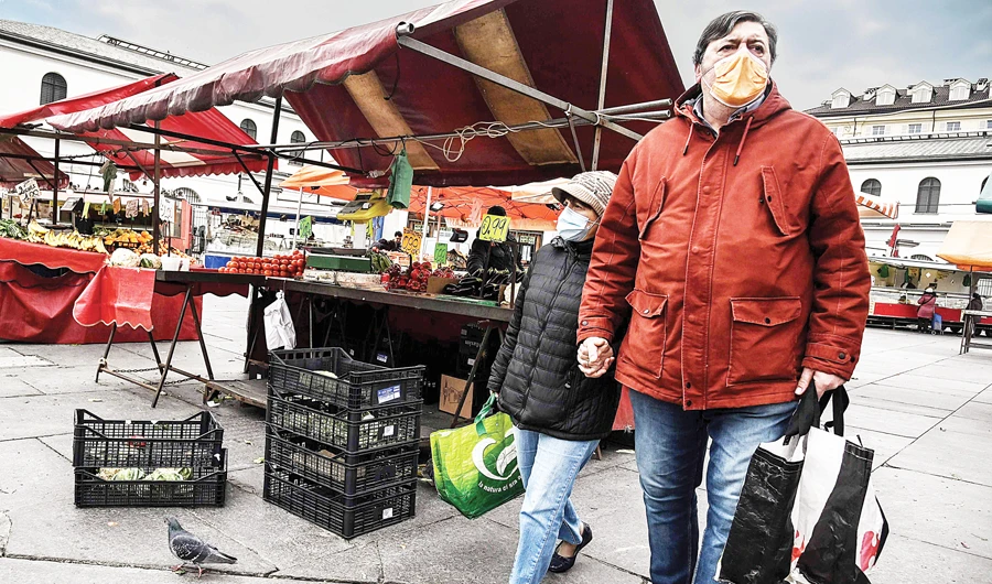 People shop at the Porta Palazzo food market in Turin, Italy, on Monday. The Italian lockdown was ordered on March 9 by Prime Minister Giuseppe Conte. (AFP)