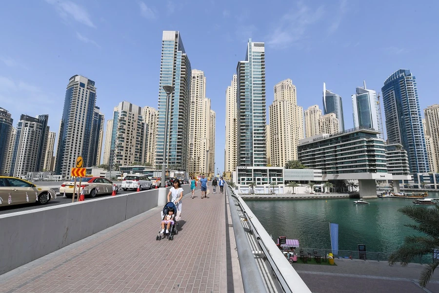 People walk across a bridge in the Emirate of Dubai on March 16, 2020. (File/AFP)