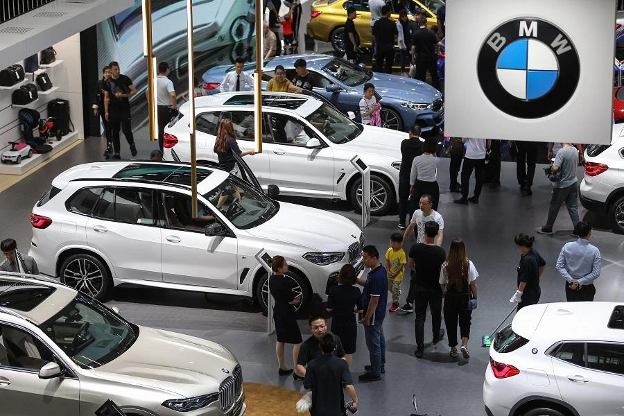 This photo taken on June 8, 2019 shows people looking at BMW cars in the 18th Shenyang, International Automobile Industry Expo in Shenyang, in China's northeastern Liaoning province. (File/AFP)