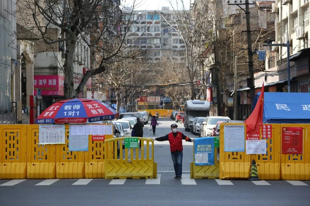 A volunteer mans a barrier set up to prevent people from entering or leaving a community in Wuhan, in China’s central Hubei province. (AFP file photo)