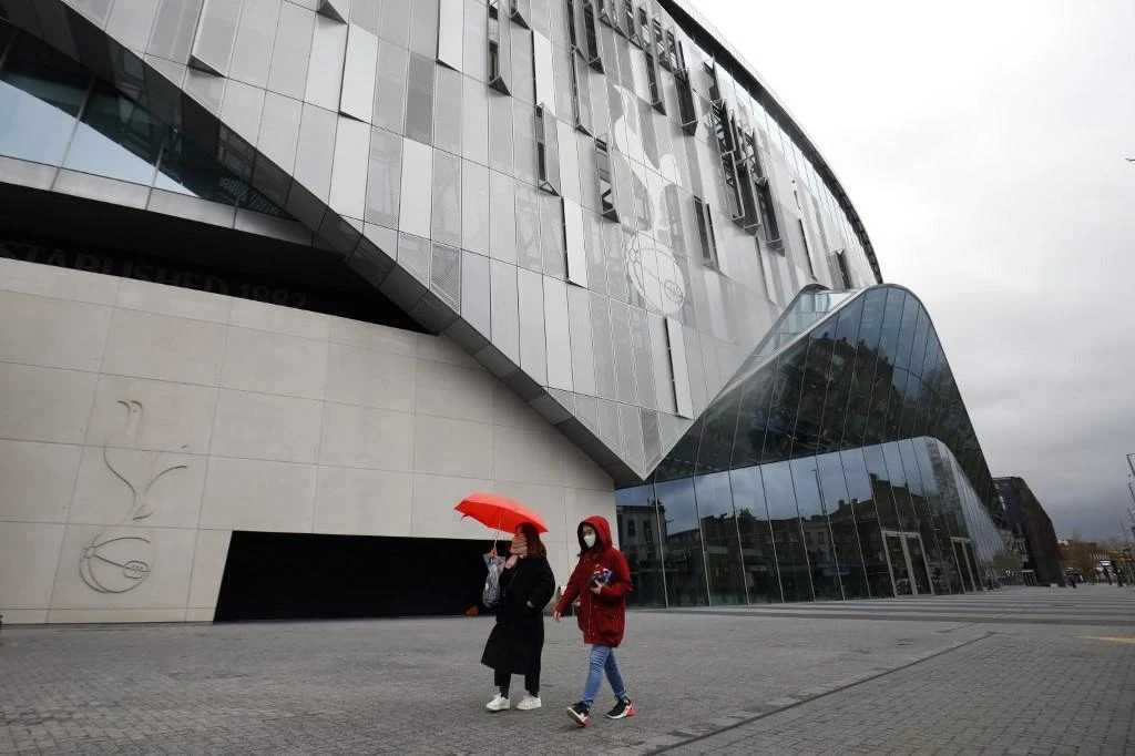 Above, a football fan wearing a protective face mask walks near the Tottenham Hotspur Stadium in London on March 15, 2020. (AFP)