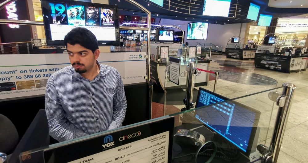 A man stands at a ticket booth of a cinema at an empty mall in Manama. (Reuters)