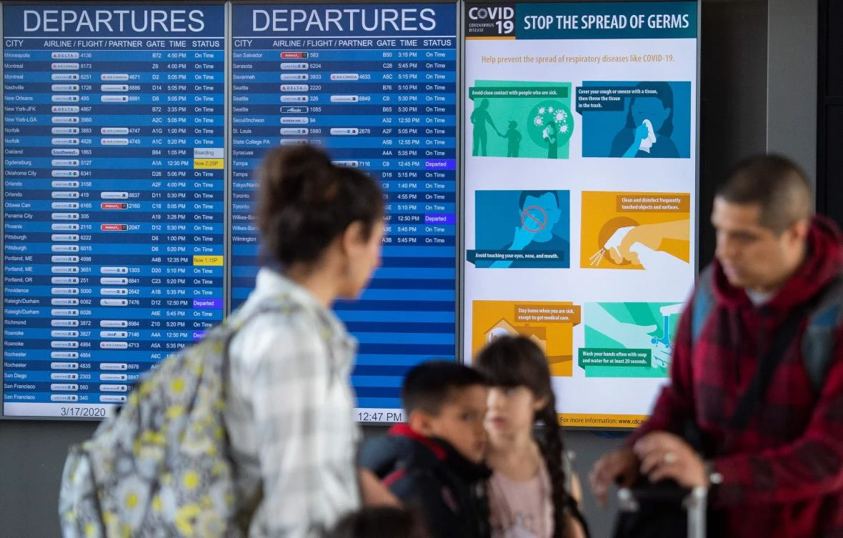 A family gets ready to go through security to depart from Dulles International airport in Dulles, Virginia on March 17, 2020. (AFP)