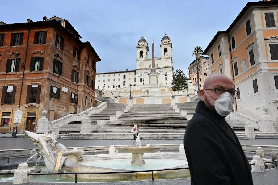 A man wearing a protection mask walks by the Spanish Steps at a deserted Piazza di Spagna in central Rome on March 12, 2020, as Italy shut all stores except for pharmacies and food shops in a desperate bid to halt the spread of a coronavirus. (AFP)