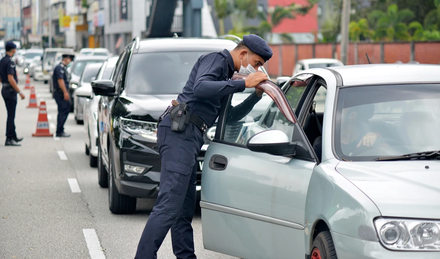 Police officers check vehicles at a roadblock to ensure that people abide by the movement control order in downtown Kuala Lumpur, Malaysia Thursday, March 19, 2020. (AP)