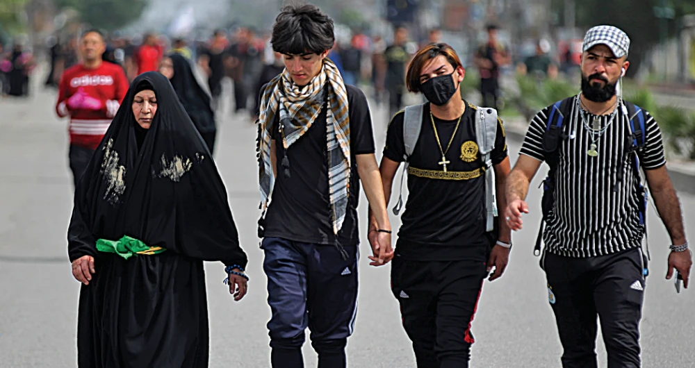 Iraqi pilgrims make their way to a shrine near Baghdad. Fears over coronavirus have hit religious tourism in Iraq, adding to the country’s financial woes. (AFP)
