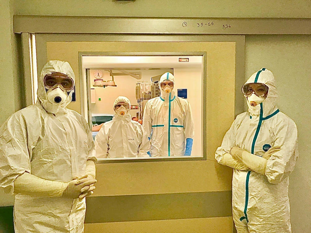 Medical staff in protective suits are seen before the delivery of a healthy baby whose mother was tested positive for coronavirus at the Attikon hospital in Athens, Greece, March 18, 2020. (Georgios Chrelias/Handout via Reuters)