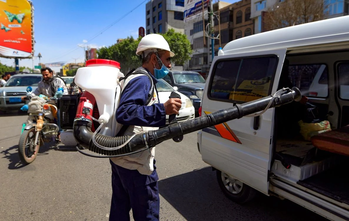 A Yemeni worker sprays a disinfecting liquid into a minivan in a street of the capital Sanaa, to limit the spread of the novel coronavirus COVID-19, on March 21, 2020. (AFP)