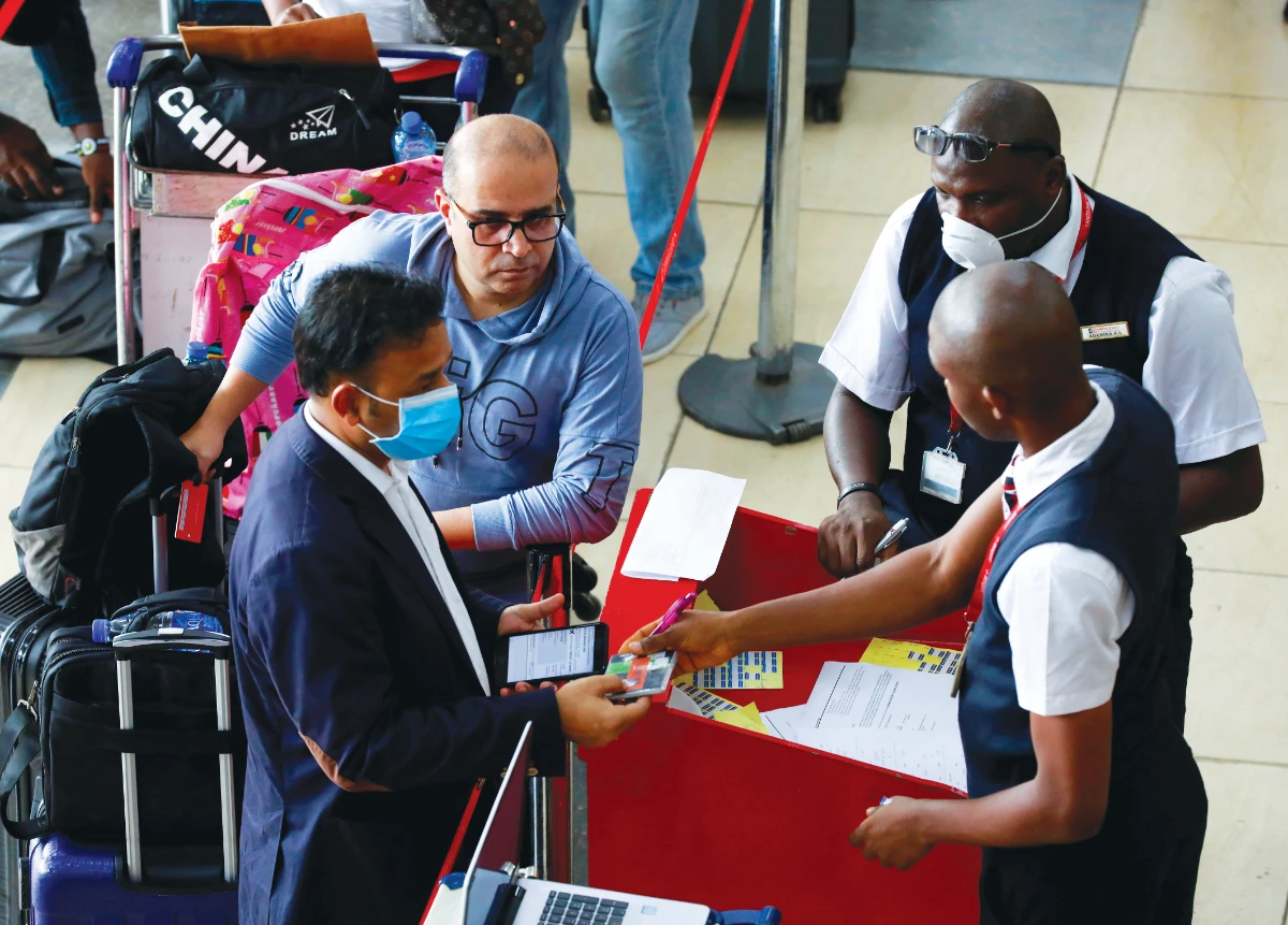 Emirates airline officials attend to passengers leaving Lagos, Nigeria. The airline is expected to suspend flights to and from the West African nation imminently. (Reuters)