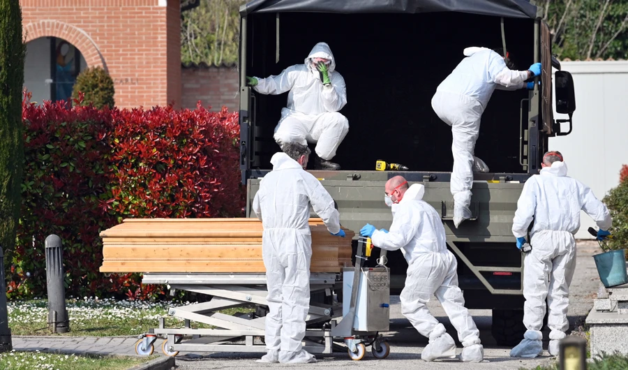 A convoy of Italian Army trucks is unloaded upon arrival from Bergamo carrying bodies of coronavirus victims to the cemetery of Ferrara, Italy, where they will be cremated, Saturday, March 21, 2020. (AP)