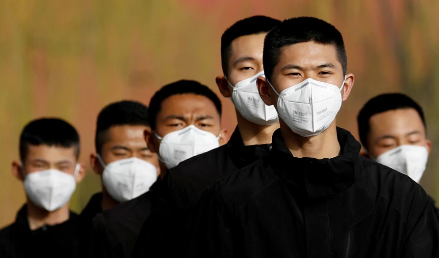 Security personnel wearing face masks to contain the spread of coronavirus disease (COVID-19) walk along a street outside the Forbidden City in Beijing, China March 18, 2020. (REUTERS)