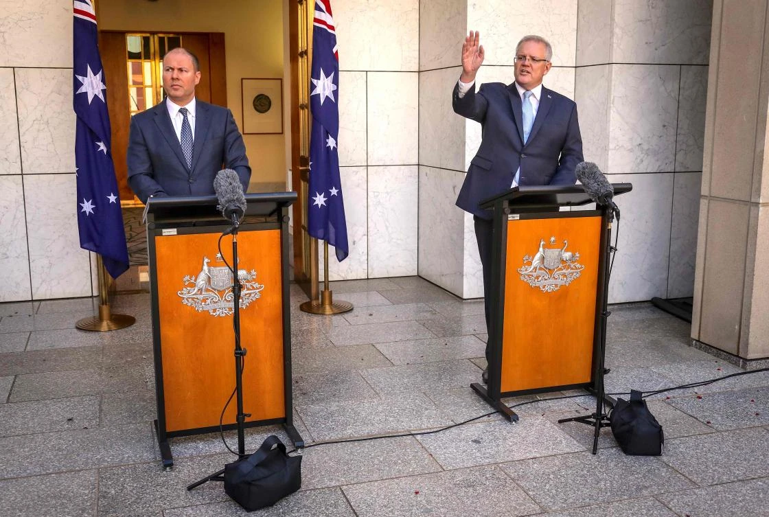 Australian Prime Minister Scott Morrison (R) speaks as he stands with the Australian Treasurer Josh Frydenberg during a press conference at Australia's Parliament House in Canberra on March 22, 2020. (AFP)
