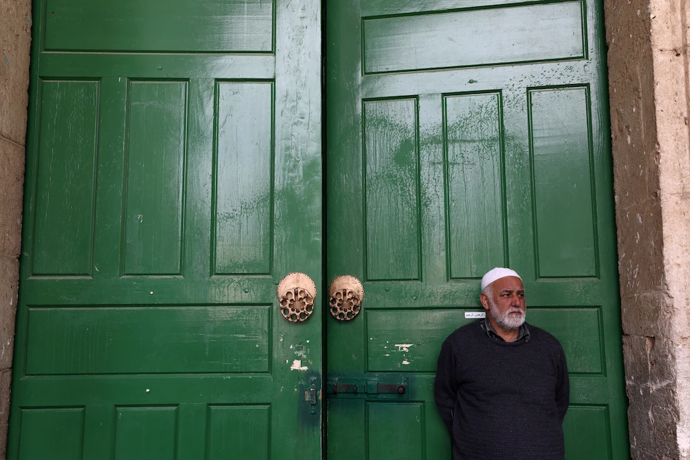An employee of the Islamic Waqf stands in front of the closed doors of Al-Aqsa mosque in the compound known to Muslims as Noble Sanctuary and to Jews as Temple Mount in Jerusalem’s Old City, after Muslim clerics shut the mosque until further notice as a precaution against coronavirus. (File/Reuters)