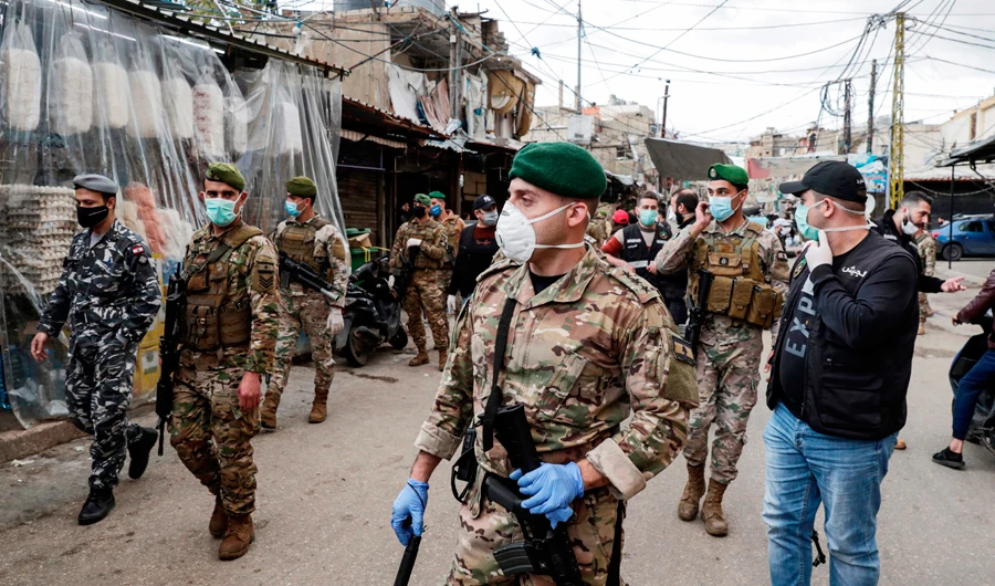 Lebanese soldiers patrol on Sunday in the market of the Palestinian refugee camp of Sabra, south Beirut, as measures were taken to shut down all shops. (AFP)