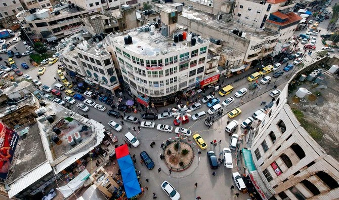 This picture taken on March 22, 2020 shows a view of vehicles crowding in a street in the city of Hebron in the occupied West Bank, as shoppers prepare to stock up ahead of a "mandatory quarantine" that was announced by the Palestinian Authority to take effect from later in the evening as part of measures against the COVID-19 coronavirus pandemic. (AFP)