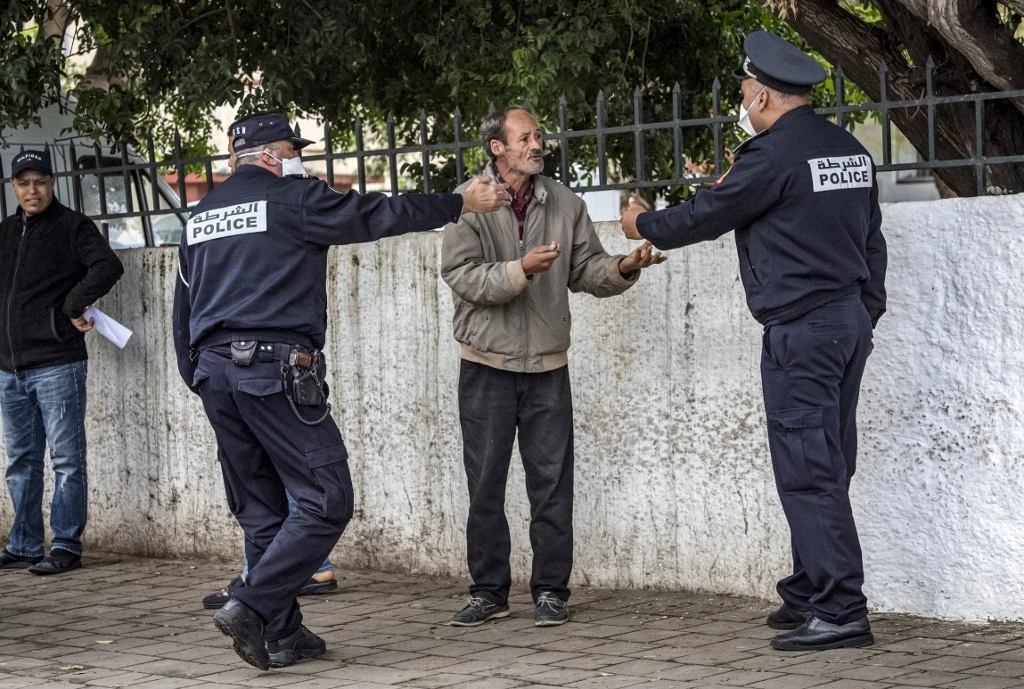 Policemen instruct a man to return home in Morocco’s capital Rabat on March 22, 2020. (AFP)