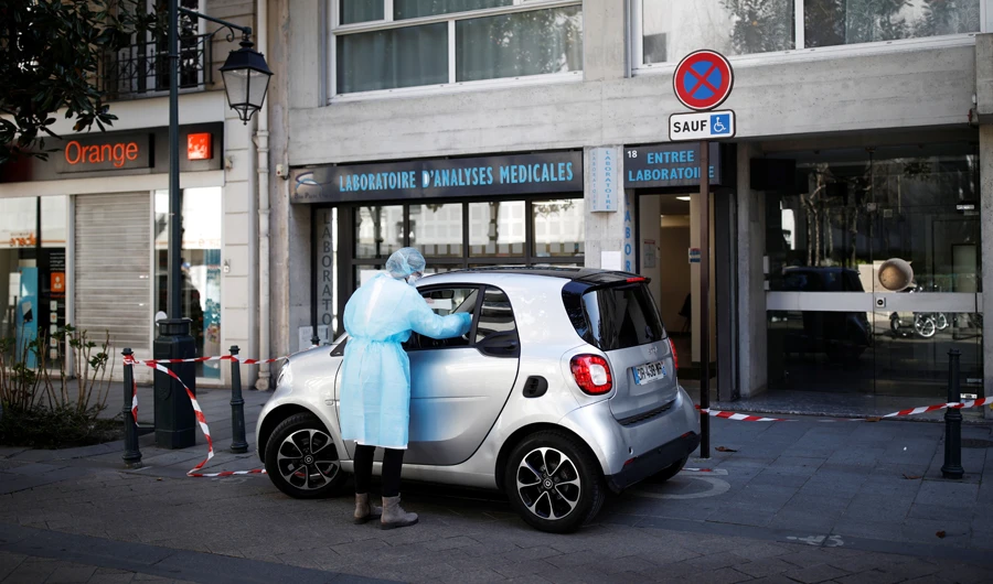 A medic tests a commuter at a drive-through testing site for the COVID-19 disease at a parking lot in front of a laboratory in Neuilly-sur-Seine near Paris. (Reuters)