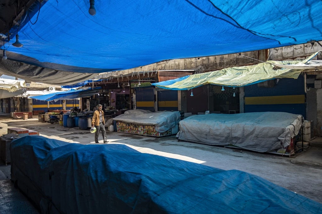 A man walks by at a deserted market in the Kurdish-majority city of Qamishli in Syria’s northeastern Hasakah province. (File/AFP)