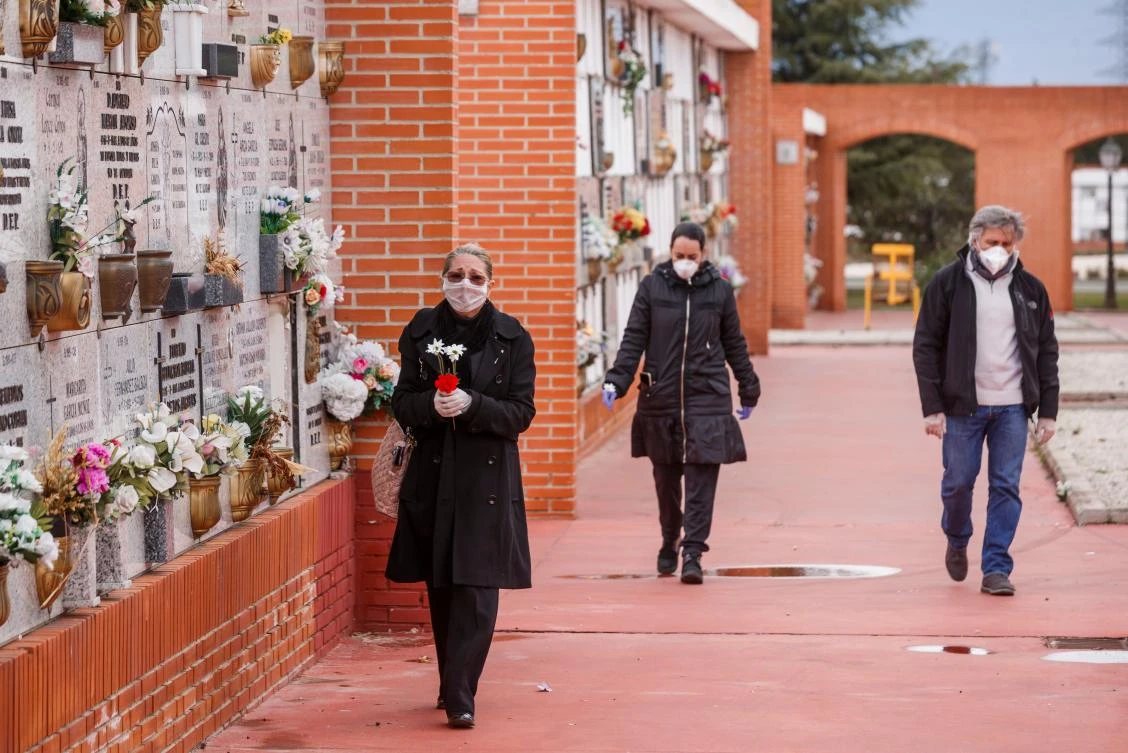 People wearing face masks arrive at the South Municipal cemetery in Madrid on March 23, 2020, to attend the burial of a man who died of the new coronavirus. (AFP file)