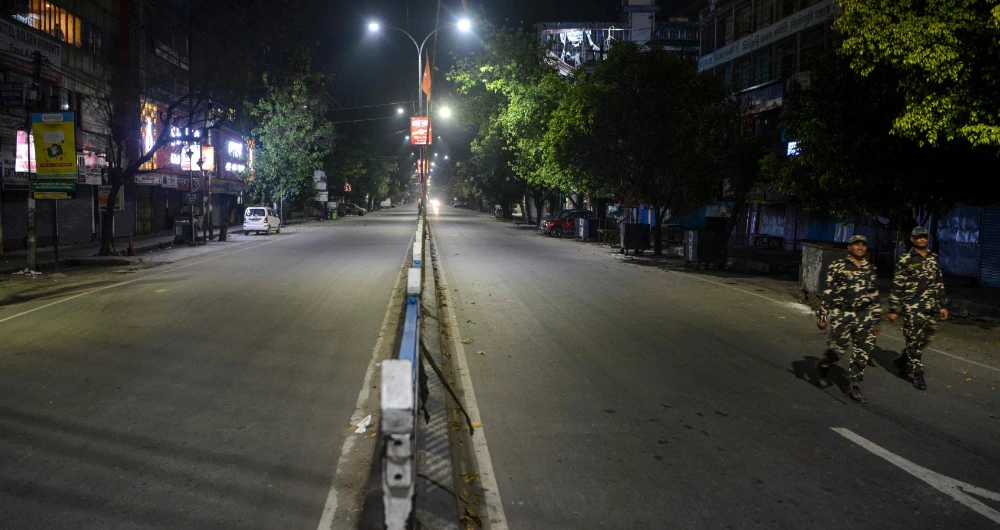 Security personnel patrol a deserted street during the first day of a 21-day nationwide lockdown in Siliguri on Wednesday. (AFP)