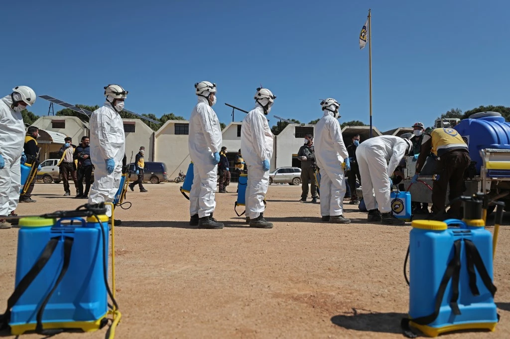 Members of the Syrian Civil Defence, also known as the "White Helmets", prepare their sterilisation equipment before sterilising a hospital in Syria's northwestern Idlib. (AFP)