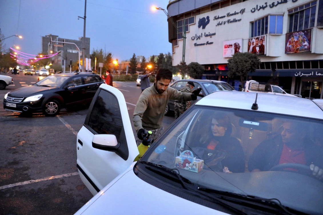 Iranian Revolutionary Guard members disinfect cars to help prevent the spread of the new coronavirus in downtown Tehran on Wednesday, March 25, 2020. (AP)