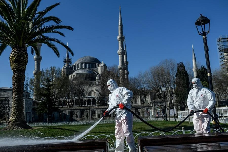 Members of the Fatih Municipality disinfect Istanbul's Sultanahmet square with the Blue Mosque seen in the backgroung to prevent the spread of the novel coronavirus (COVID-19) on March 21, 2020. (File/AFP)
