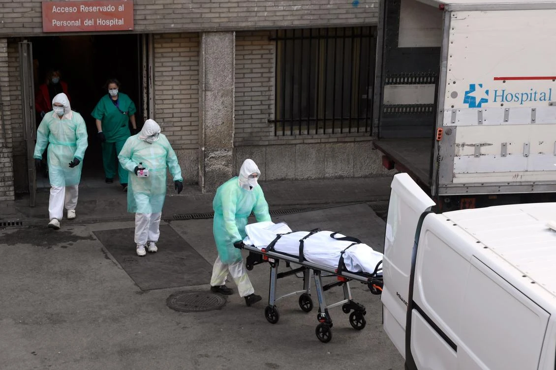 A health worker carries a body on a stretcher outside Gregorio Maranon hospital in Madrid on March 25, 2020. (AFP)