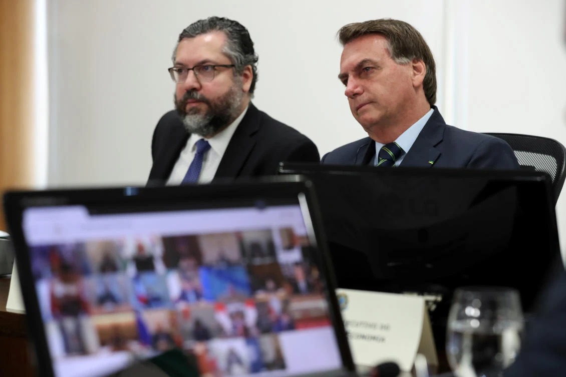 Brazil’s President Jair Bolsonaro and Foreign Minister Ernesto Araujo take part in a video link, held by G20 leaders to discuss the coronavirus outbreak, at the Planalto Palace in Brasilia. (Reuters)