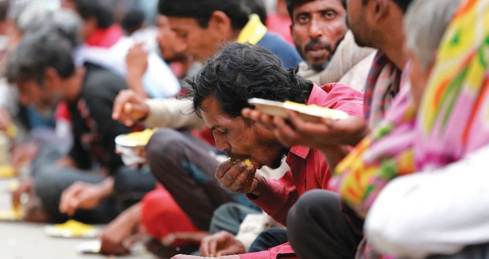 India’s homeless eat a meal delivered by the government in New Delhi. A nationwide lockdown has left more than 800 million people facing acute food shortages. (AP)