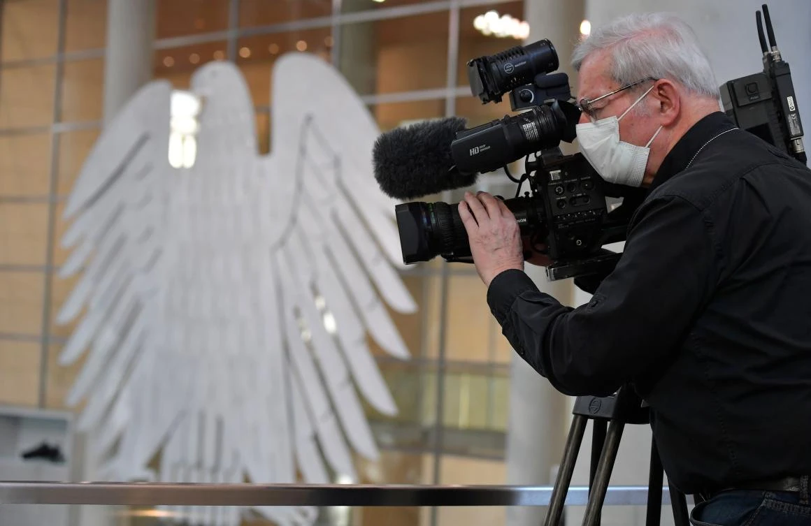A cameraman wears a face mask as he films a session at the Bundestag, Germany’s lower house of parliament, in Berlin on March 25, 2020. (AFP)