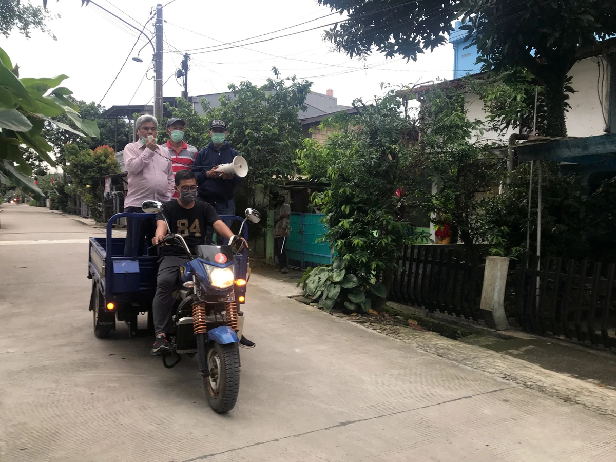 An Indonesian doctor broadcasts advice on preventing the spread of coronavirus (COVID-19) from the back of a motor-tricycle, in Depok, near Jakarta, Indonesia. (Reuters)