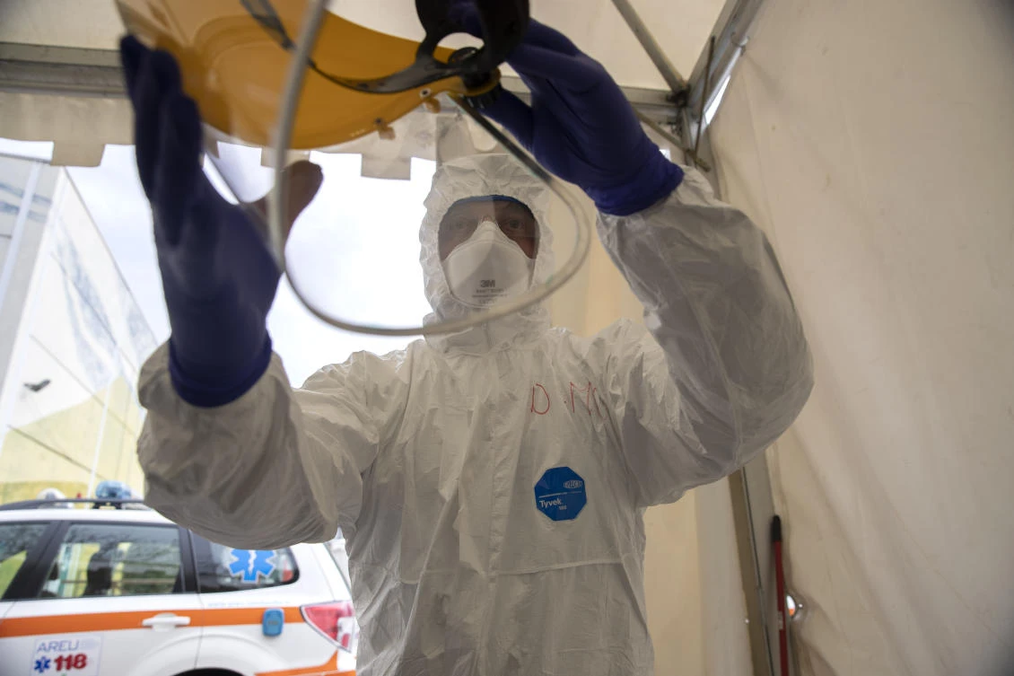 Nurse Abramo Pozzaglio puts on sanitation gear at one of the emergency structures that were set up to ease procedures for the arrival of Covid-19 patients at the Spedali Civili Hospital, in Brescia, Italy, Friday, March 27, 2020. (AP)