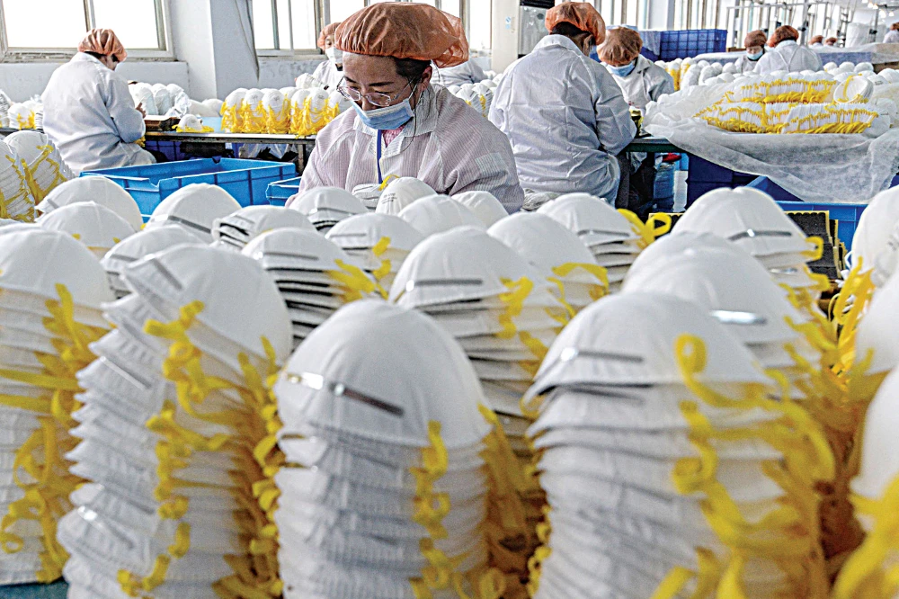 Workers producing face masks, now a lucrative product for exporting to Europe, at a factory in Handan in China’s northern Hebei province. (AFP)