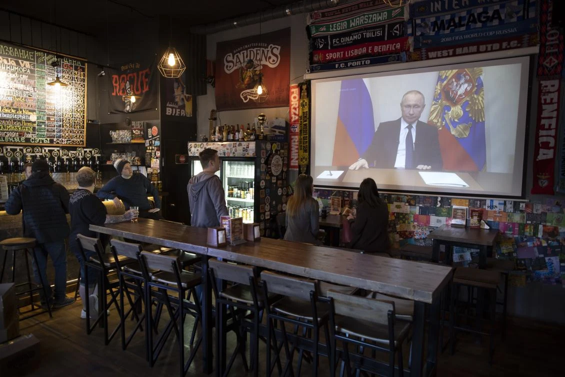 A few visitors and staff of the pub watching the broadcast of Russian President Vladimir Putin addresses Russian citizens on the State Television channels in Moscow, Russia, Wednesday, March 25, 2020. (File/AP/Alexander Zemlianichenko)