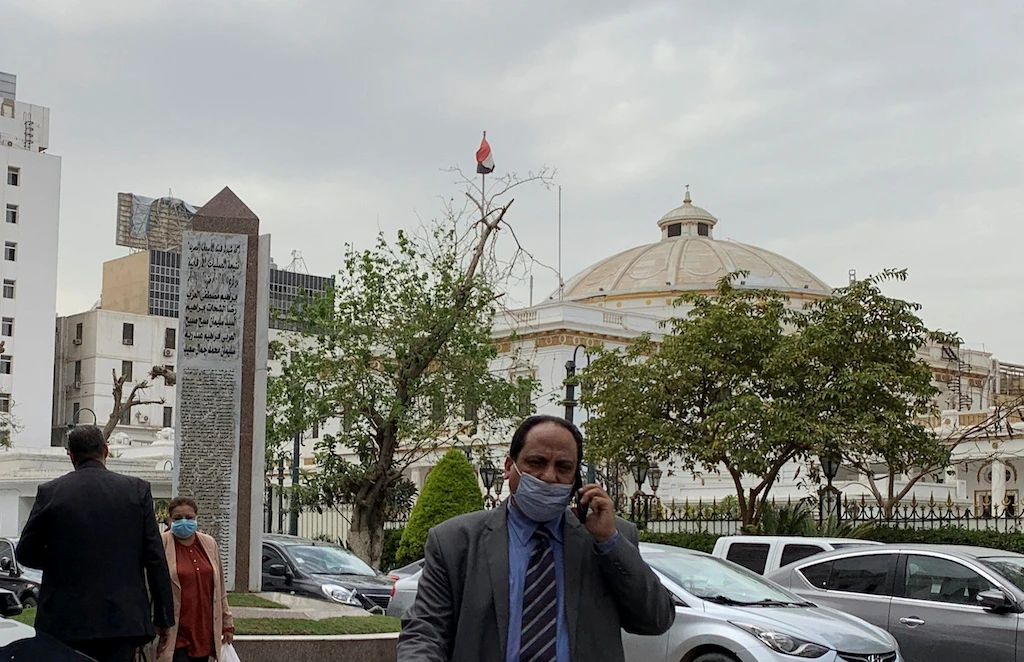 An employee of the Egyptian Ministry of Health wears a protective mask as he walks near the House of Representatives, following an outbreak of the coronavirus disease (COVID-19), in Cairo. (AFP)